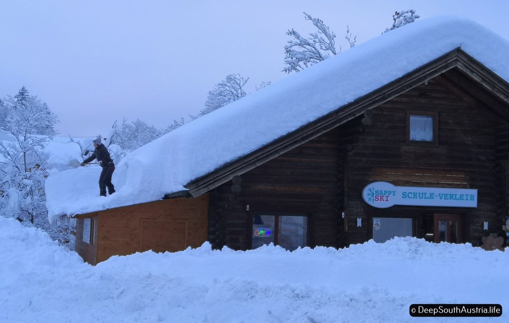 Shovelling snow from roof at Dreiländereck ski resort, in Carinthia, Austria.