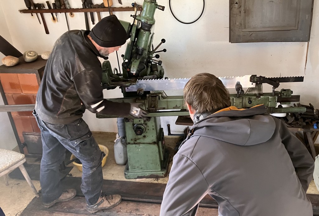 Man sharpens vertical blade from saw mill